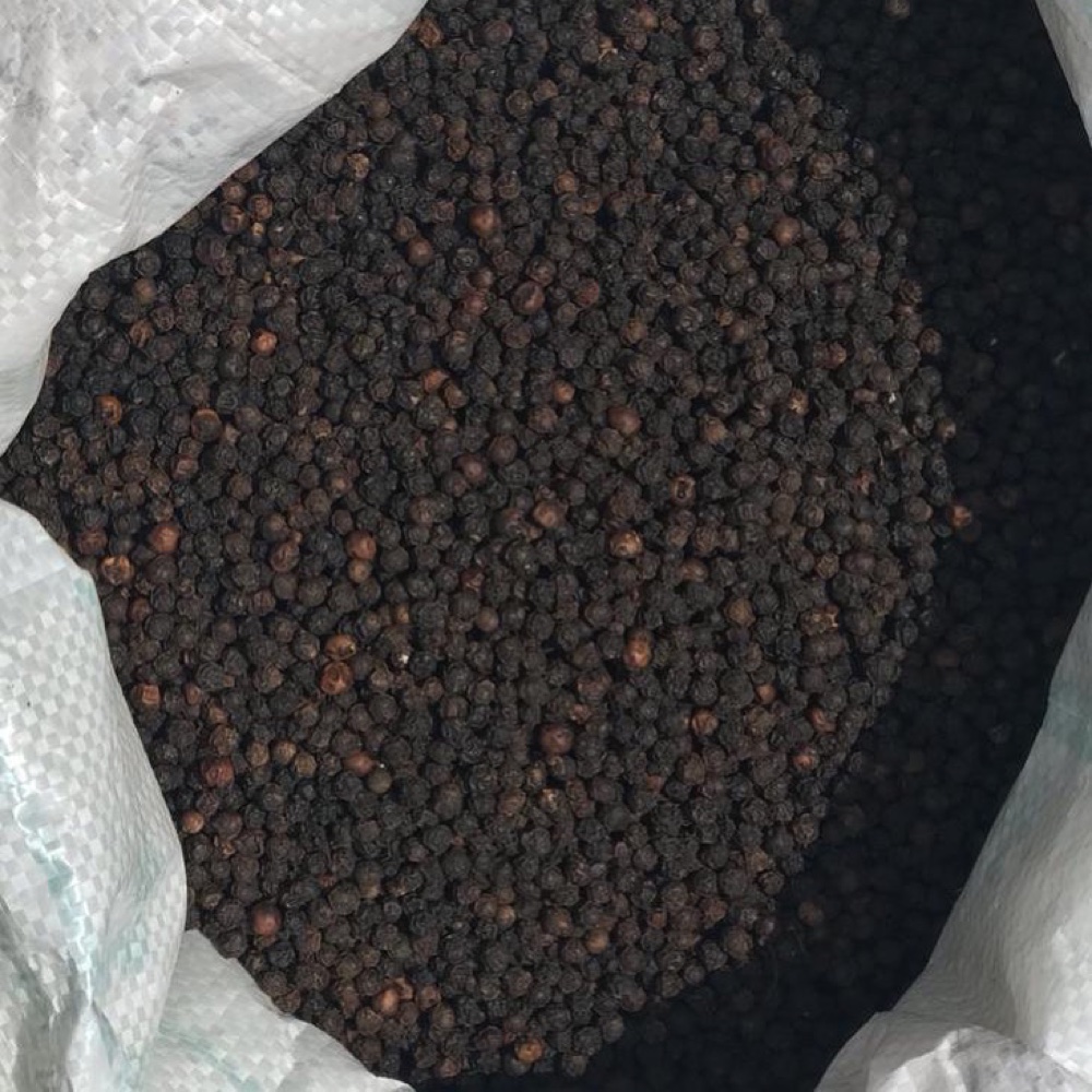 Bulk black peppercorns in a storage sack.